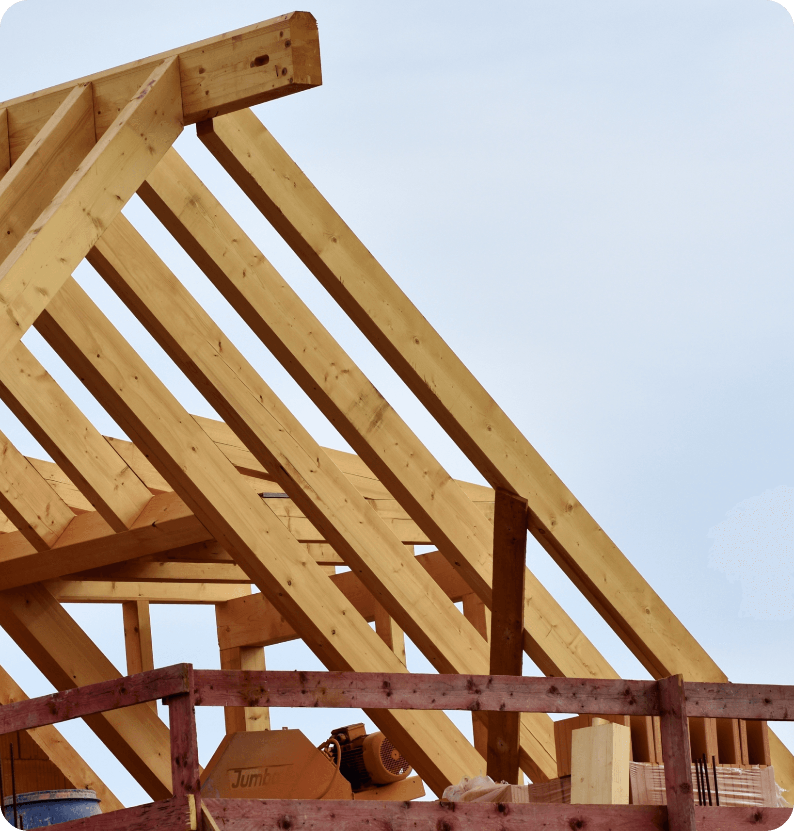 A picture of a timber based house in construction. The picture shows the roof of the house and the wooden beams that support it.